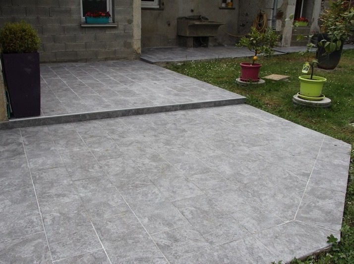 Pose de carrelage sur terrasse extérieure avec marche